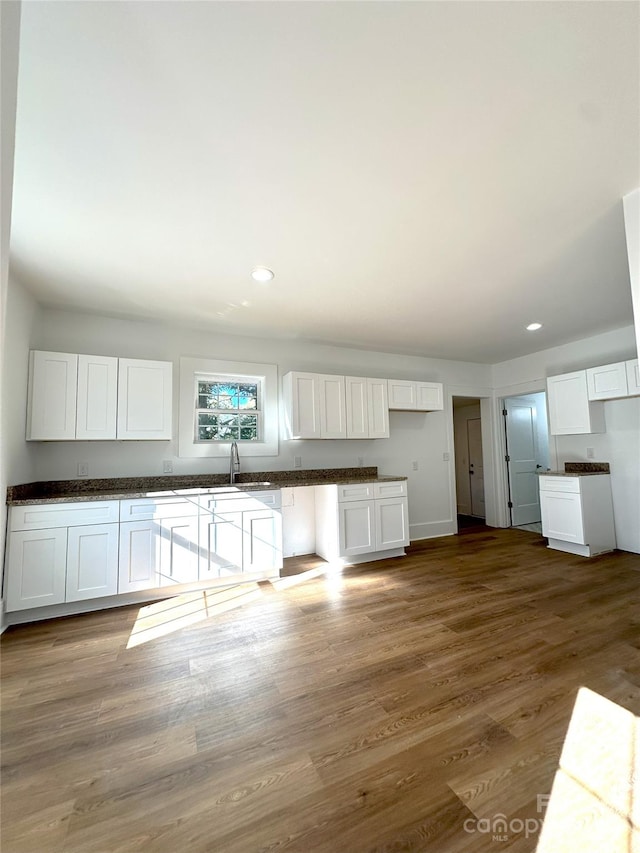 kitchen with sink, dark hardwood / wood-style flooring, and white cabinets