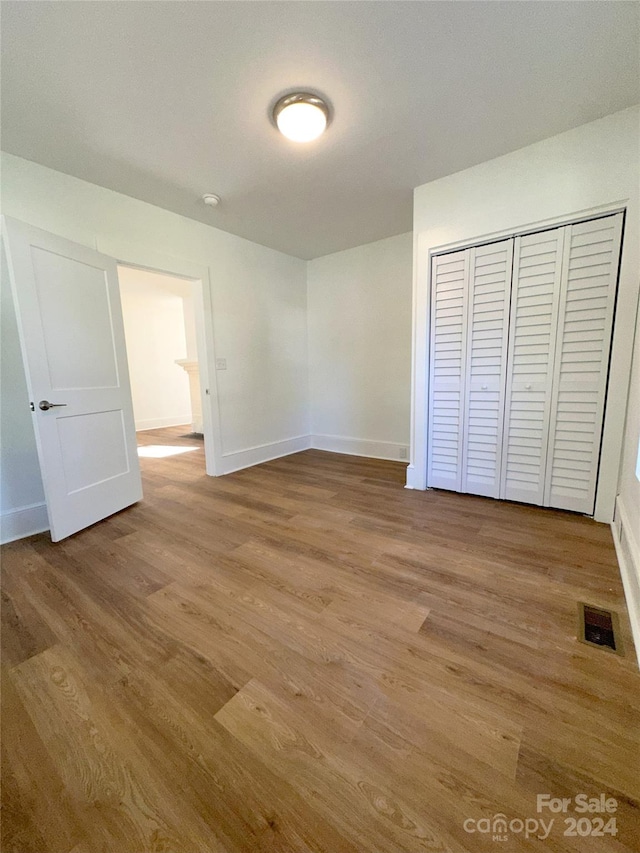 unfurnished bedroom featuring a closet and light hardwood / wood-style flooring