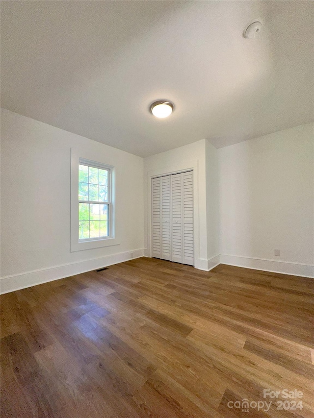 unfurnished bedroom with a closet, hardwood / wood-style floors, and a textured ceiling