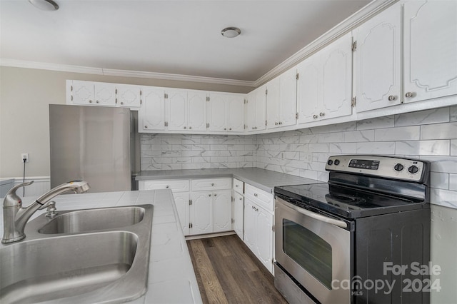 kitchen with dark hardwood / wood-style floors, stainless steel appliances, sink, white cabinets, and tasteful backsplash