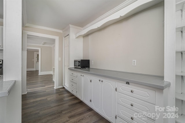 kitchen featuring dark wood-type flooring, white cabinets, and crown molding