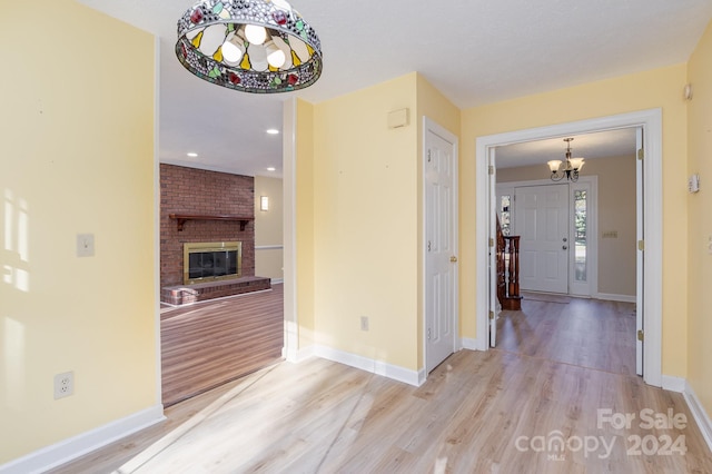 hallway featuring light hardwood / wood-style floors and a chandelier