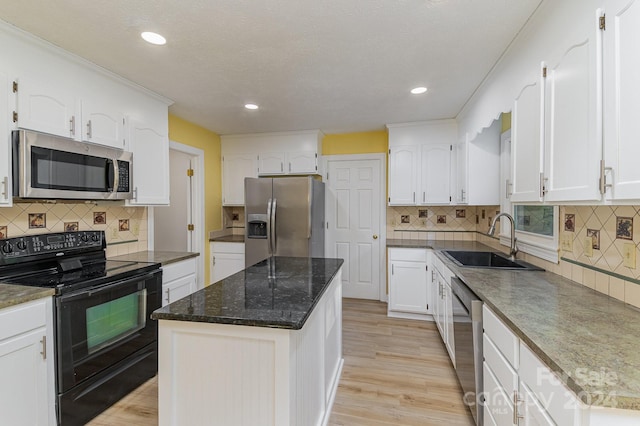 kitchen featuring backsplash, a kitchen island, sink, light hardwood / wood-style floors, and stainless steel appliances