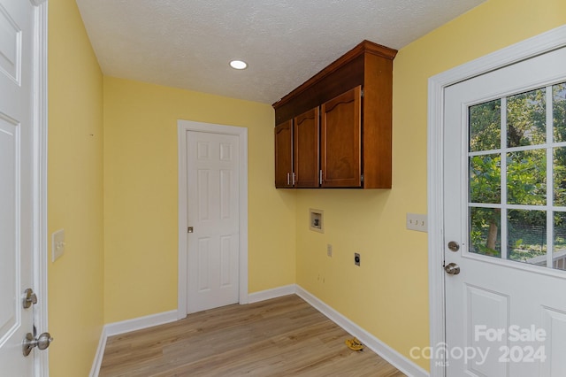 laundry room with cabinets, light hardwood / wood-style flooring, washer hookup, and electric dryer hookup