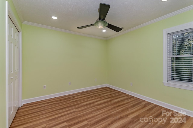 unfurnished bedroom with a textured ceiling, wood-type flooring, a closet, and ceiling fan