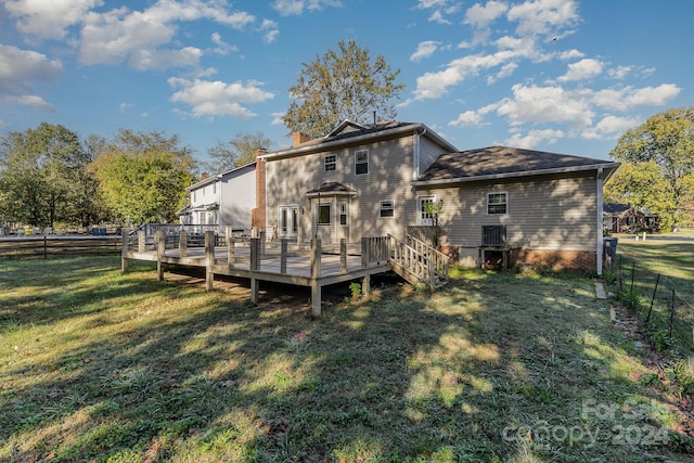 rear view of house with a deck and a lawn