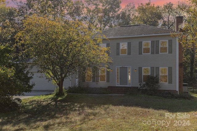 view of front of house featuring a garage and a lawn