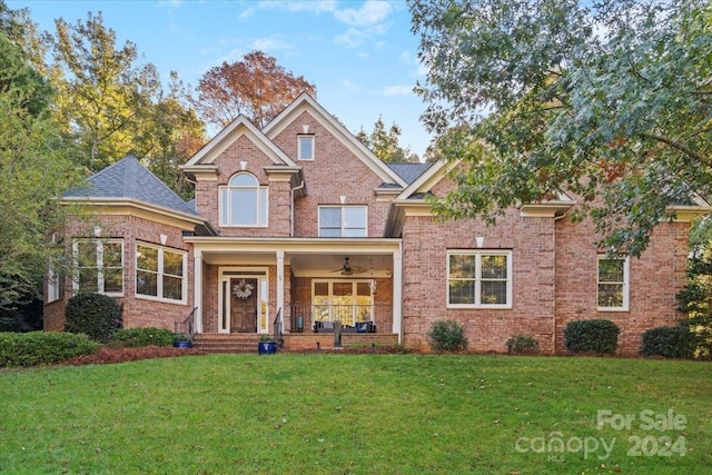 view of front facade with a front yard, ceiling fan, and a porch