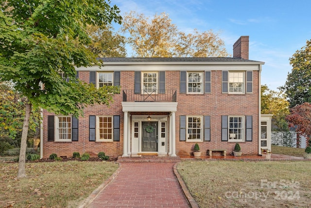 colonial inspired home featuring a front lawn