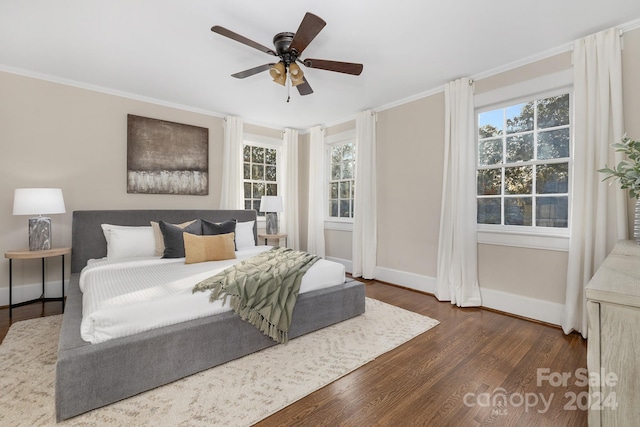 bedroom with dark wood-type flooring, ceiling fan, and crown molding