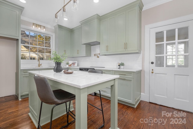 kitchen featuring tasteful backsplash, a breakfast bar, dark hardwood / wood-style floors, and crown molding