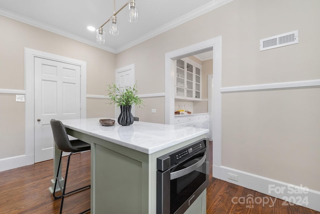 kitchen featuring ornamental molding, green cabinets, dark hardwood / wood-style flooring, a breakfast bar, and oven