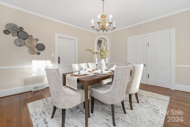 dining space featuring ornamental molding, dark hardwood / wood-style flooring, and an inviting chandelier