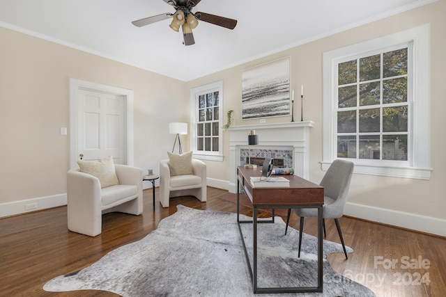 home office featuring a fireplace, dark wood-type flooring, ceiling fan, and crown molding