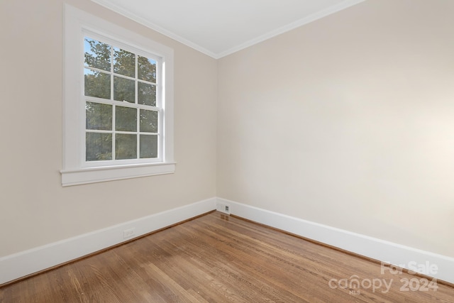 spare room featuring ornamental molding and hardwood / wood-style flooring