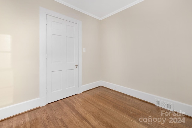 empty room featuring hardwood / wood-style floors and ornamental molding