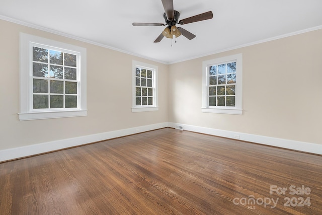 spare room with ornamental molding, ceiling fan, wood-type flooring, and a healthy amount of sunlight