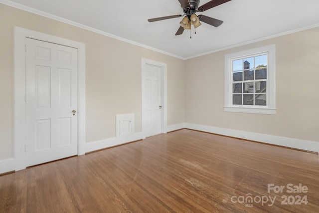 empty room featuring ceiling fan, hardwood / wood-style flooring, and ornamental molding