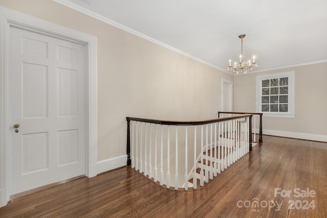 stairs with hardwood / wood-style flooring, ornamental molding, and a notable chandelier