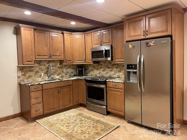 kitchen featuring light tile patterned floors, light stone countertops, sink, and appliances with stainless steel finishes