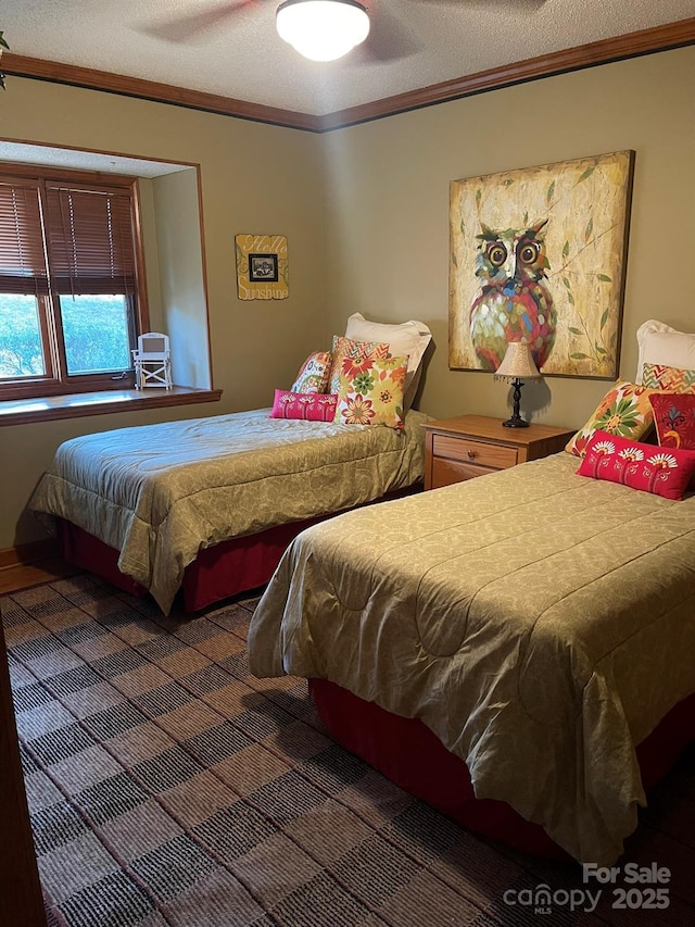 bedroom featuring a textured ceiling, ceiling fan, and ornamental molding