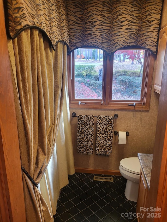 bathroom featuring visible vents, vanity, tile patterned flooring, and toilet