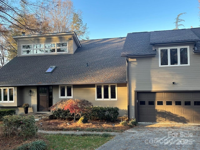 view of front of house with roof with shingles and an attached garage