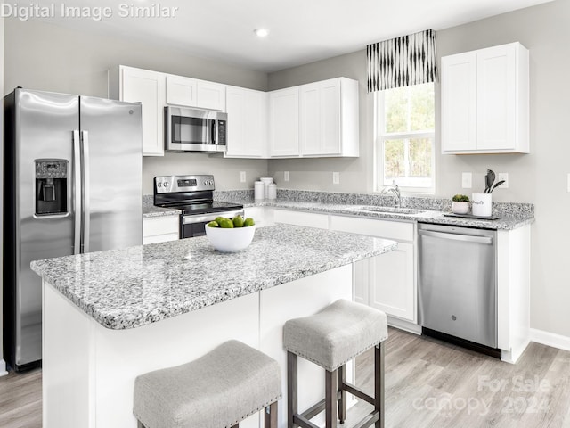 kitchen featuring stainless steel appliances, a center island, and white cabinets