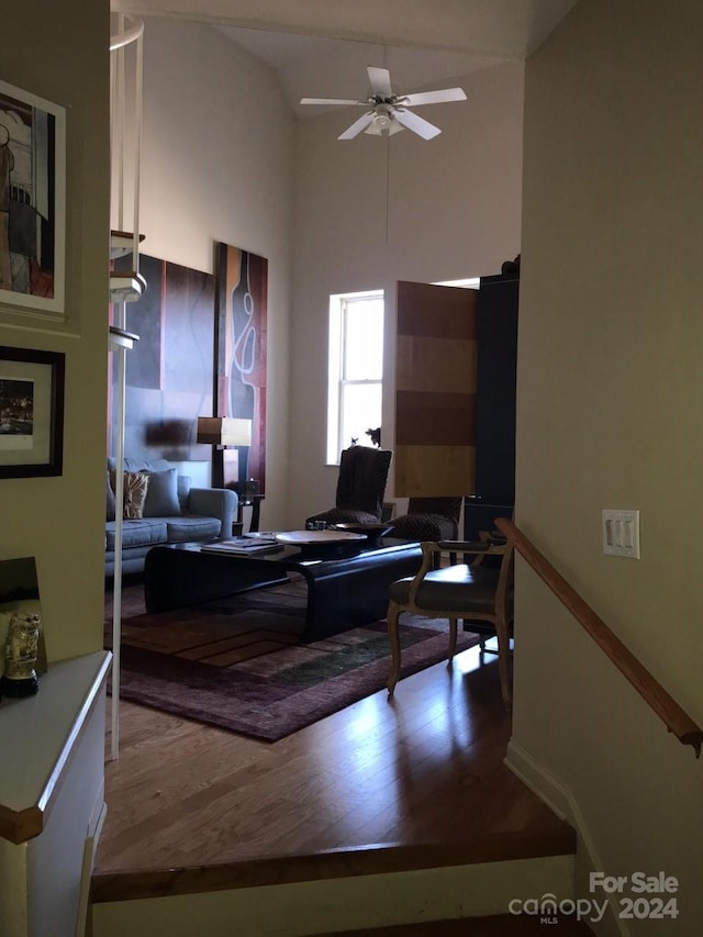 living room with hardwood / wood-style floors, vaulted ceiling, and ceiling fan