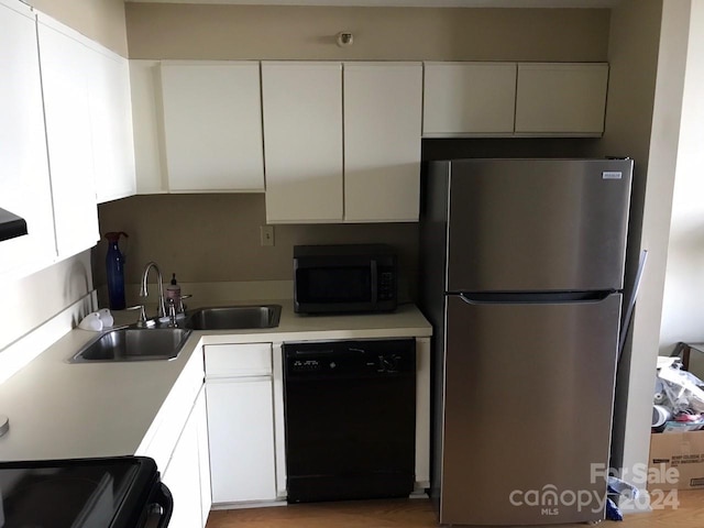 kitchen with white cabinets, stainless steel appliances, light hardwood / wood-style flooring, and sink