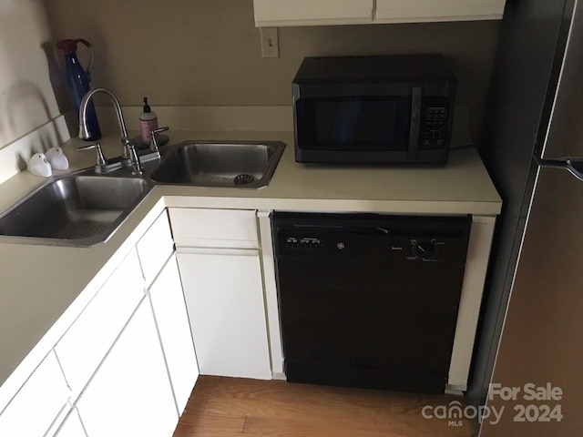 kitchen with white cabinets, hardwood / wood-style floors, stainless steel appliances, and sink