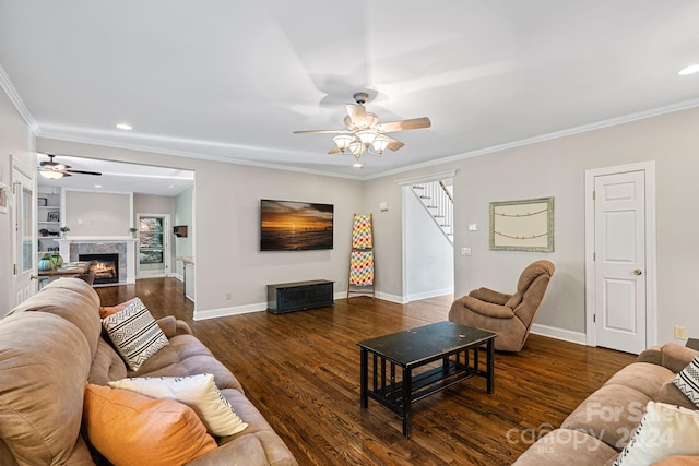 living room featuring crown molding, dark hardwood / wood-style flooring, a high end fireplace, and ceiling fan