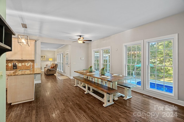 dining area featuring ceiling fan, dark wood-type flooring, and sink