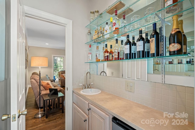 bar featuring dark hardwood / wood-style floors, sink, and tasteful backsplash