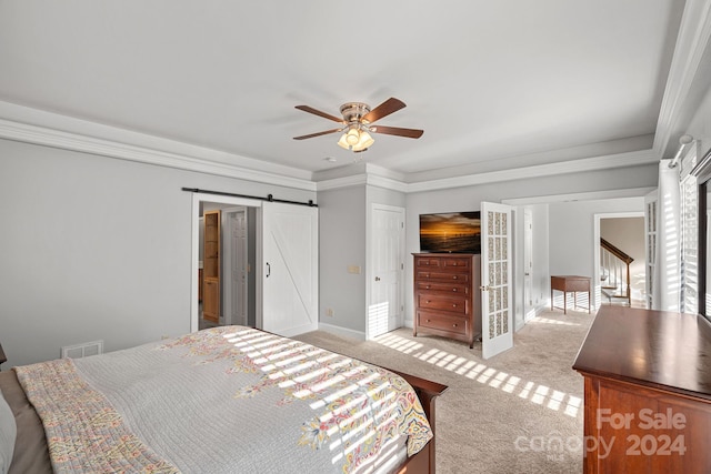 carpeted bedroom featuring a barn door, ceiling fan, and ornamental molding