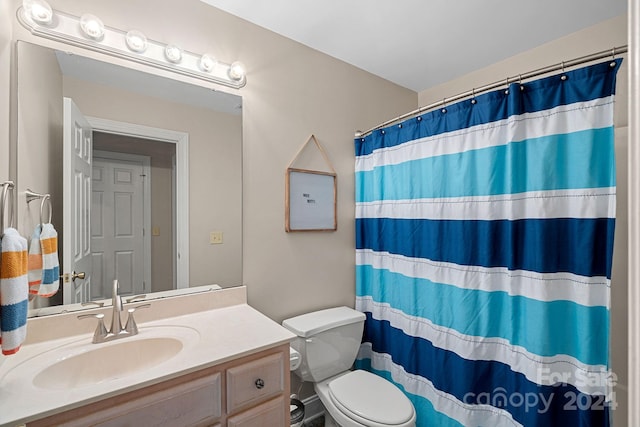 bathroom featuring a shower with shower curtain, vanity, and toilet