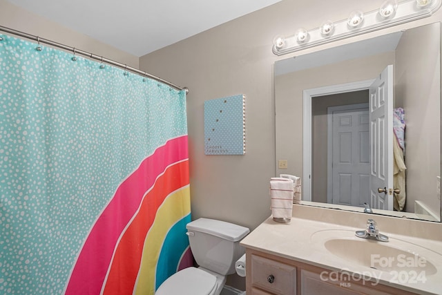 bathroom featuring a shower with shower curtain, vanity, and toilet