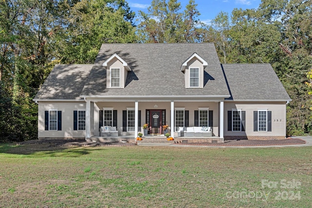 cape cod house featuring a front lawn and covered porch