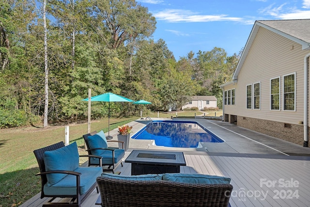 view of swimming pool with a yard, a fire pit, and a deck