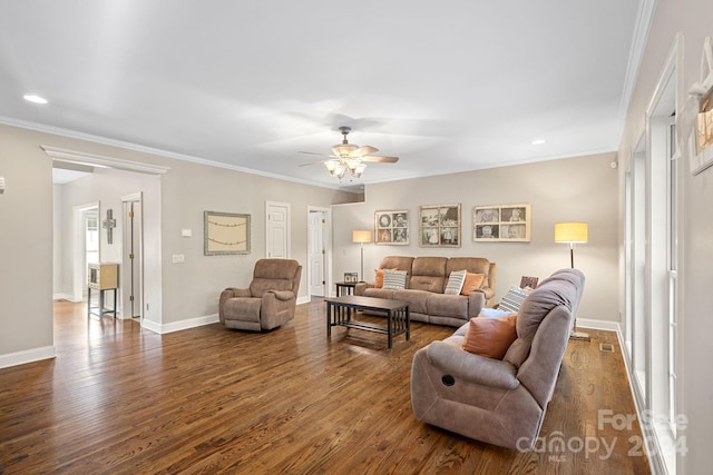 living room with ceiling fan, crown molding, and dark wood-type flooring