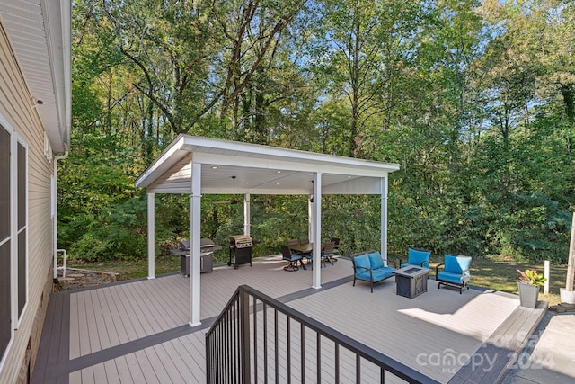 wooden deck with a grill and an outdoor living space with a fire pit