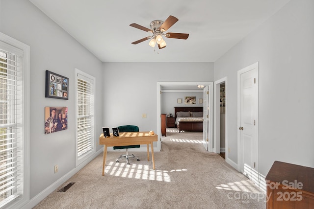 carpeted office space with ceiling fan