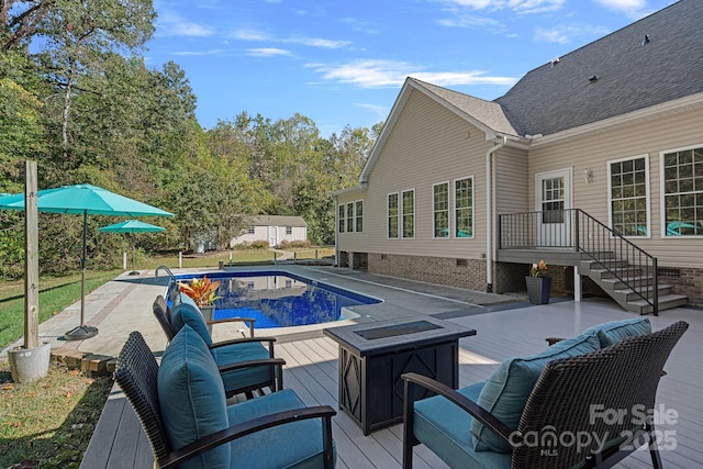 view of pool featuring an outdoor fire pit and a deck