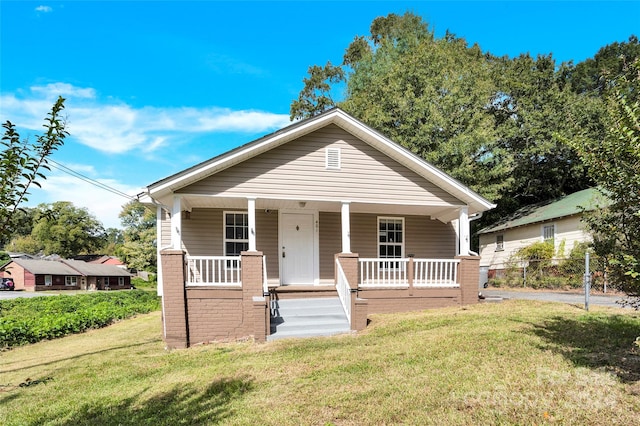 bungalow-style house featuring covered porch and a front lawn