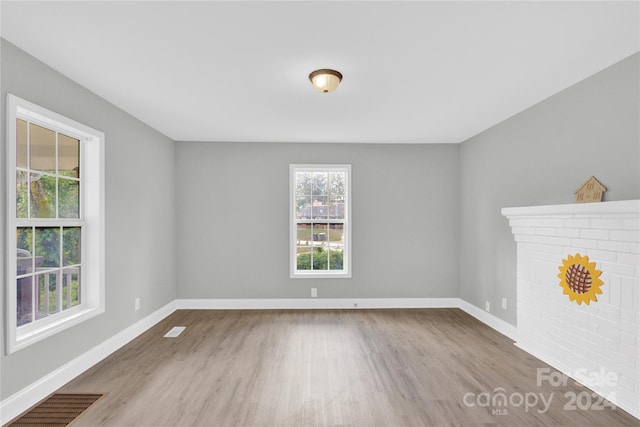 unfurnished room with a fireplace and light wood-type flooring