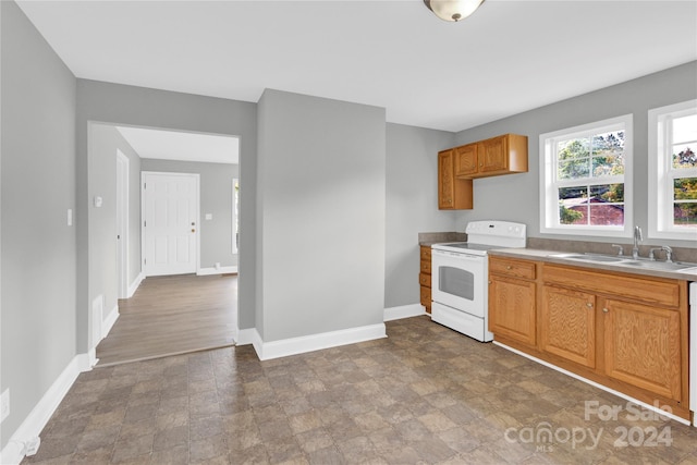 kitchen with sink, white range, and wood-type flooring