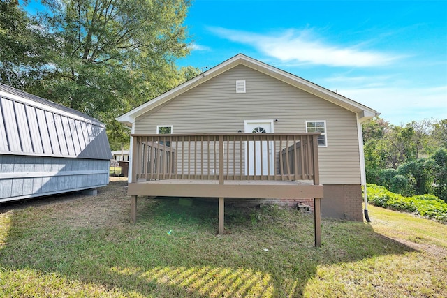 back of house with a wooden deck and a lawn