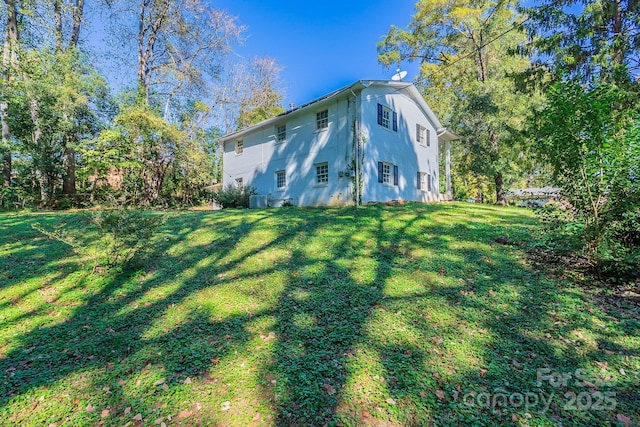 view of property exterior featuring a lawn, cooling unit, and stucco siding