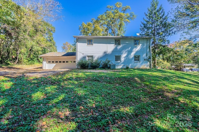 view of front of home featuring driveway, central AC unit, an attached garage, and a front yard