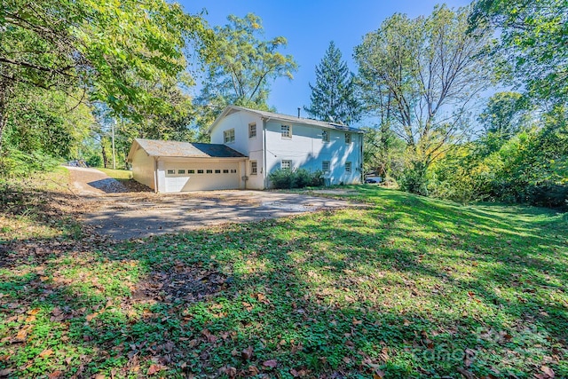 view of side of property featuring a garage, a yard, and driveway